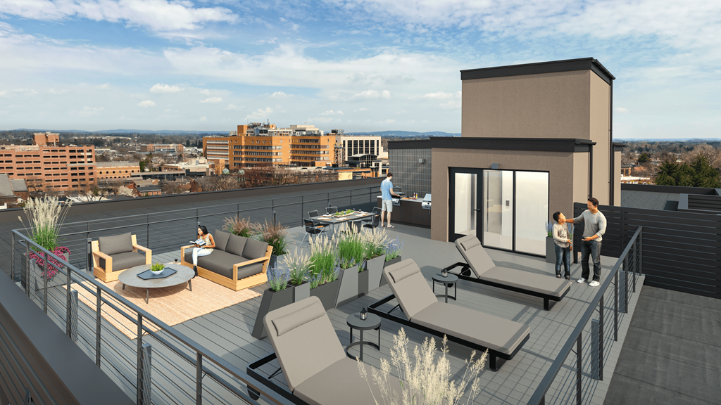 Apartments in Lancaster | a rendering of a rooftop terrace with furniture and a city in the background