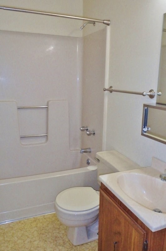 a bathroom with a toilet and a tub and a sink