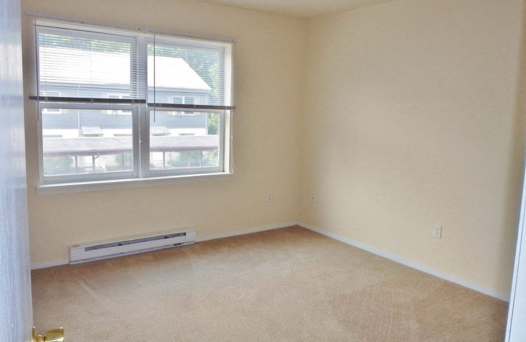 an empty room with a window and carpet