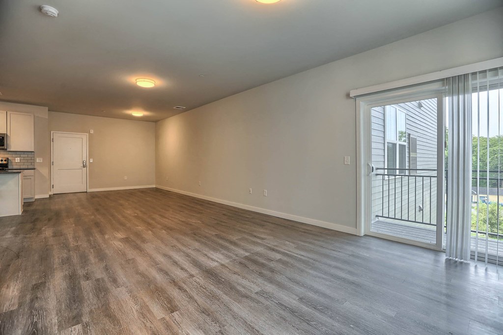 a living room with a large window and a door to a balcony