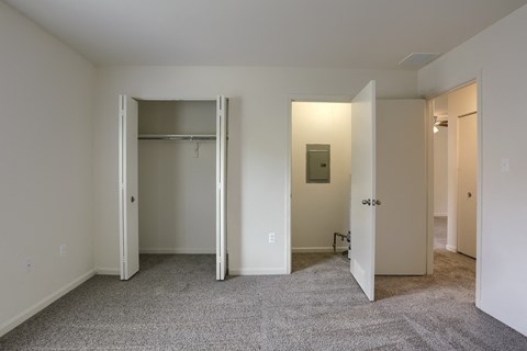a living room with a carpeted floor and a door to a closet
