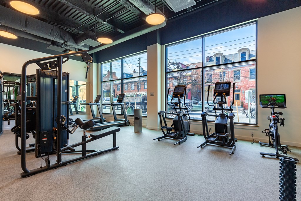 A gym with a view of the city outside the window.