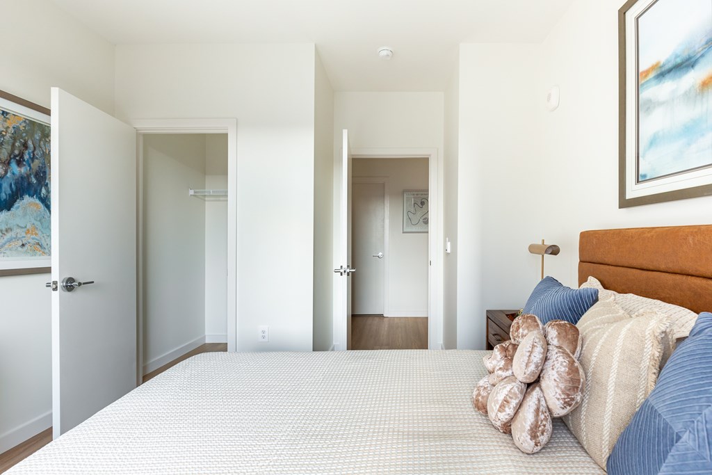 A bedroom with a large bed and a painting on the wall.