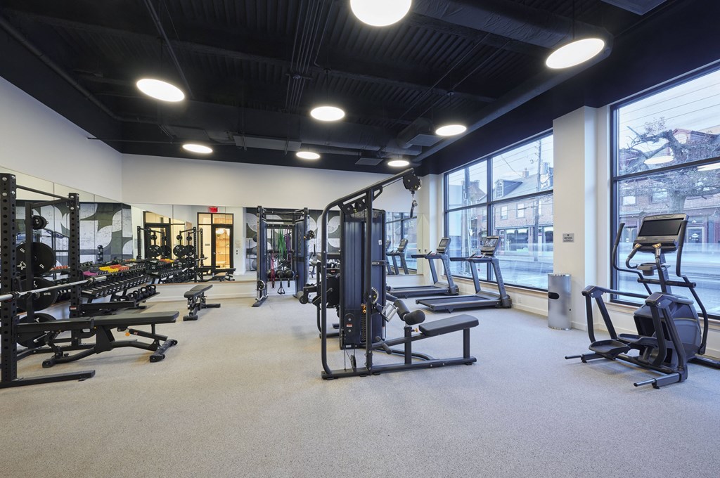 a gym with weights and other exercise equipment and large windows