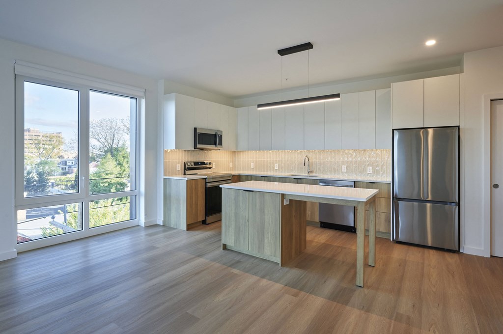 a kitchen with an island and a stainless steel refrigerator
