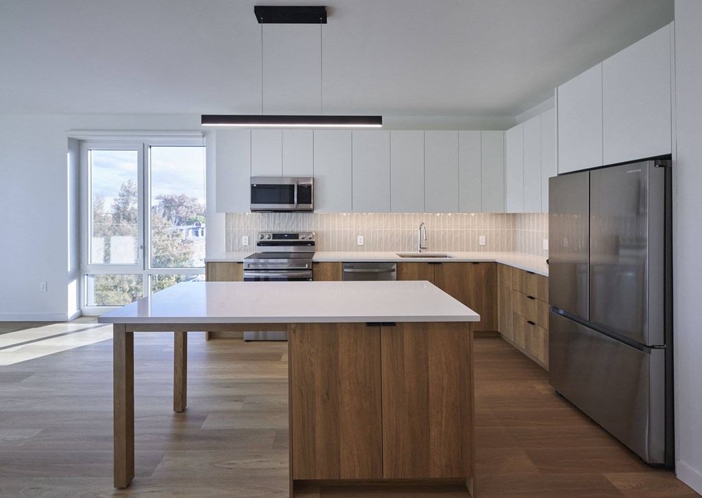 a kitchen with a large island and stainless steel appliances
