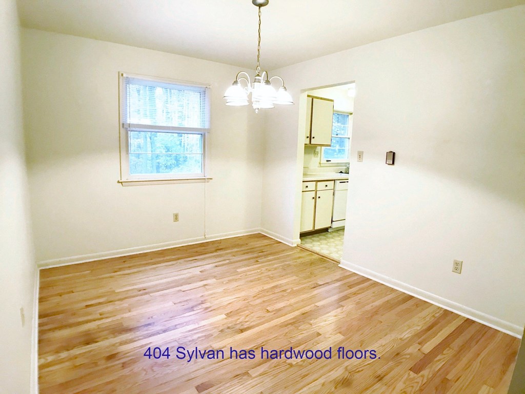 an empty living room with hardwood floors and a window