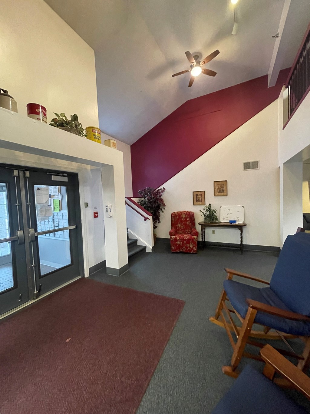 a living room with a red wall and a sliding glass door