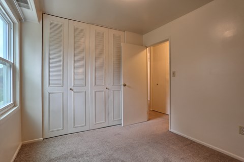 a bedroom with two closets and a door to a hallway