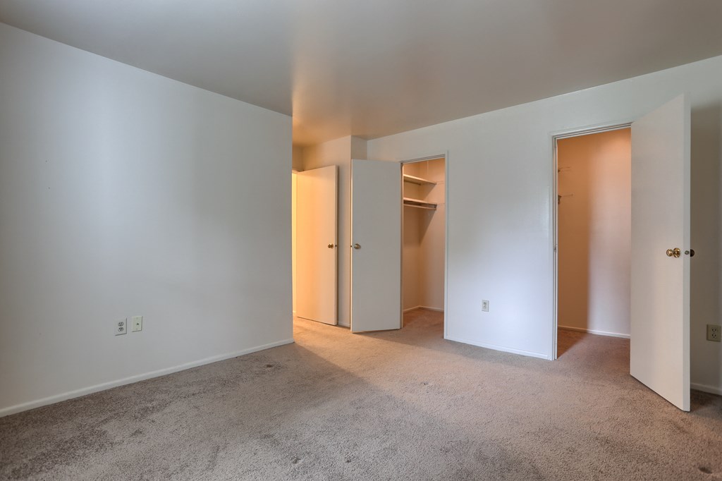 a living room with white walls and a door to a closet
