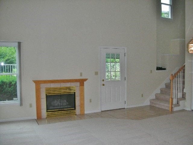 an empty living room with a fireplace and stairs