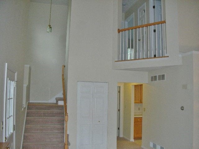 an empty house with a staircase and a white door