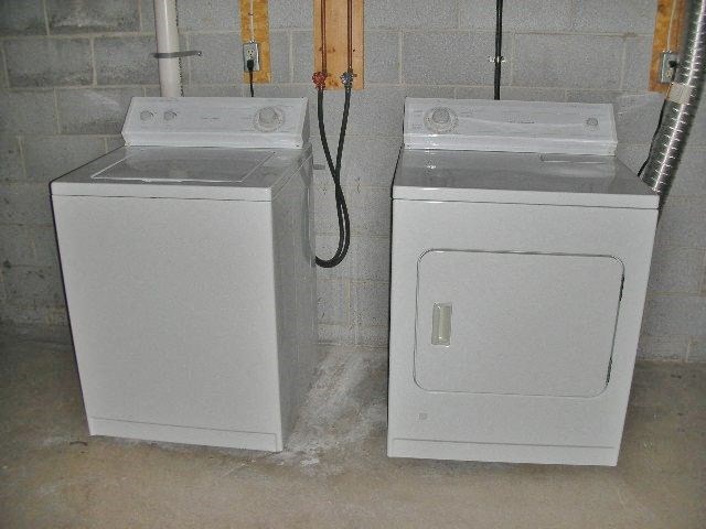 two washing machines sitting next to each other in a room