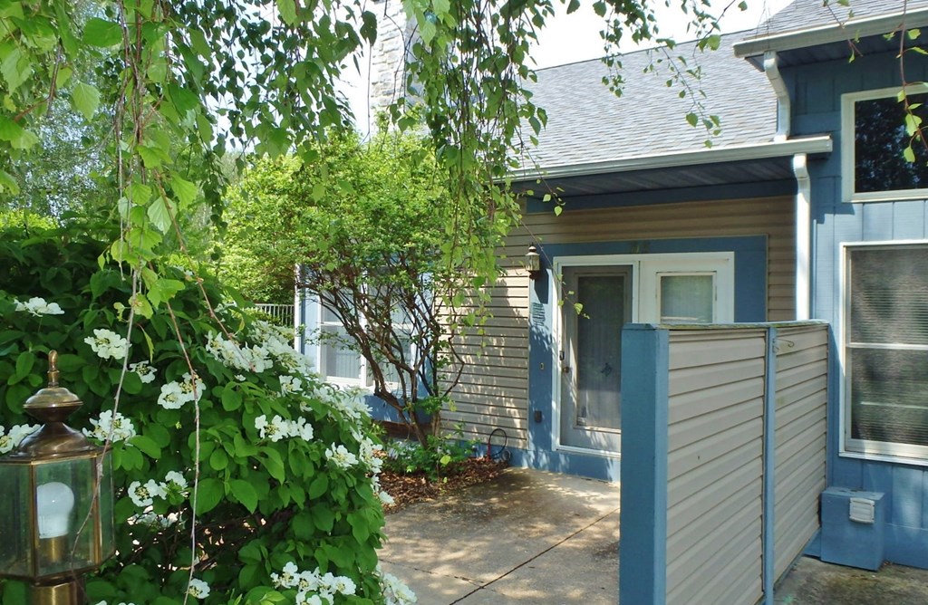 the front of our house with a walkway and a blue fence