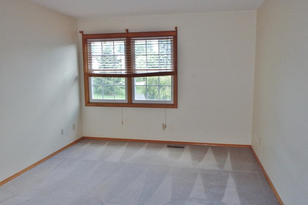 an empty room with a window and a tiled floor