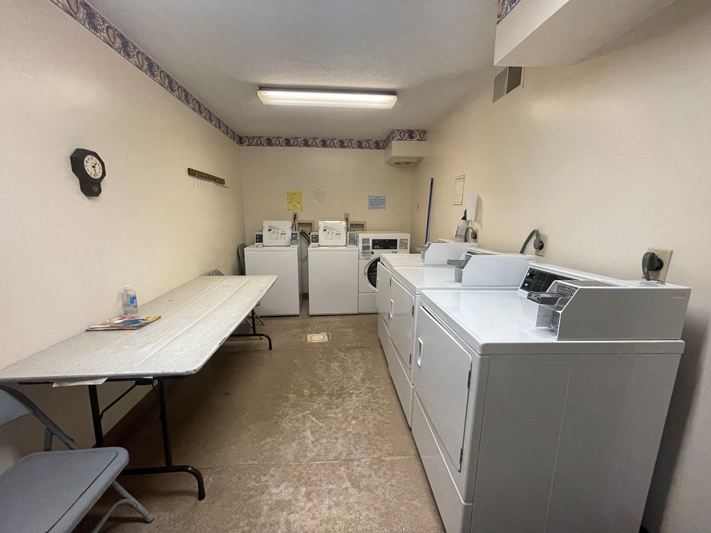 a laundry room with washer and dryer and a table