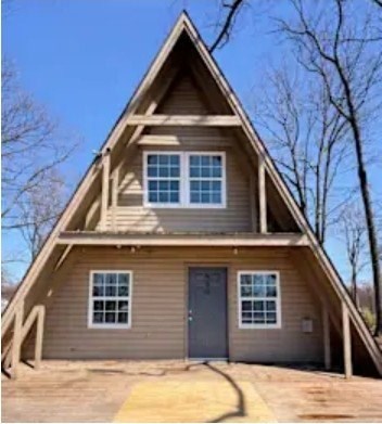 A small house with a triangular roof and a grey door.