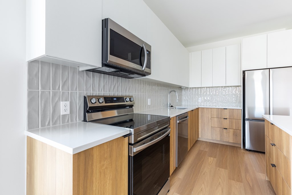 A modern kitchen with wooden cabinets and stainless steel appliances.