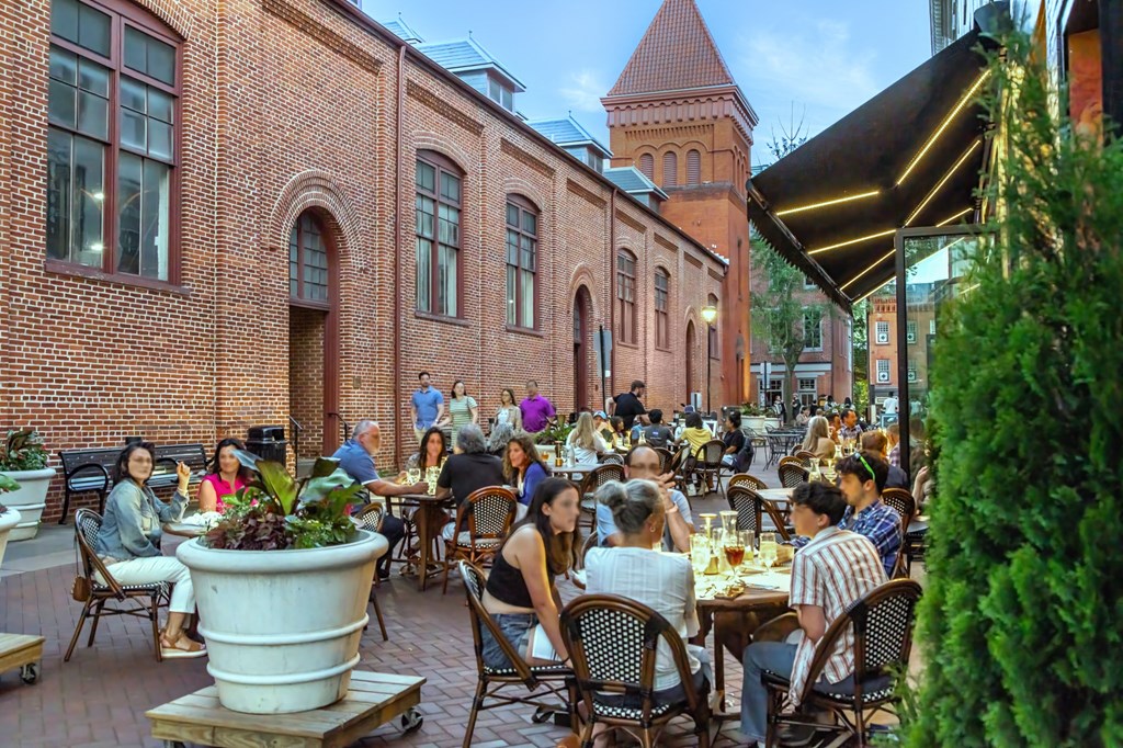 people sitting at tables outside of a restaurant