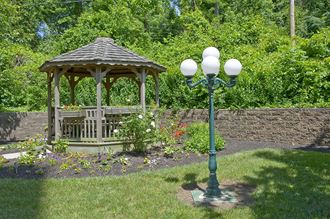 a garden with a gazebo and a lamp post