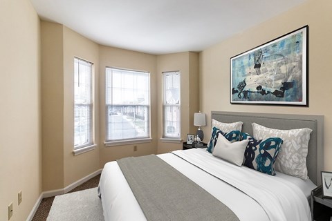 A bedroom with a large bed and a painting on the wall.