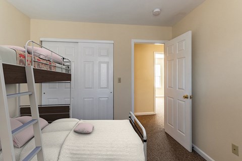 A bedroom with a bunk bed and a carpeted floor.