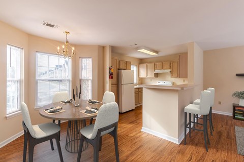A kitchen with a table and chairs in front of a window.
