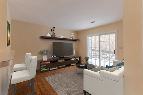 A living room with a white couch, a television, and a chair.