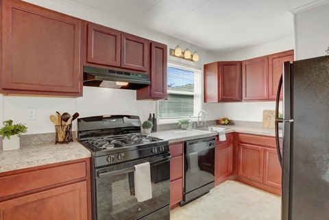 a kitchen with black appliances and wooden cabinets