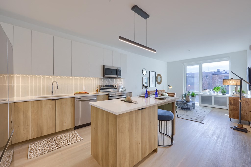 A modern kitchen with wooden cabinets and a bar stool.