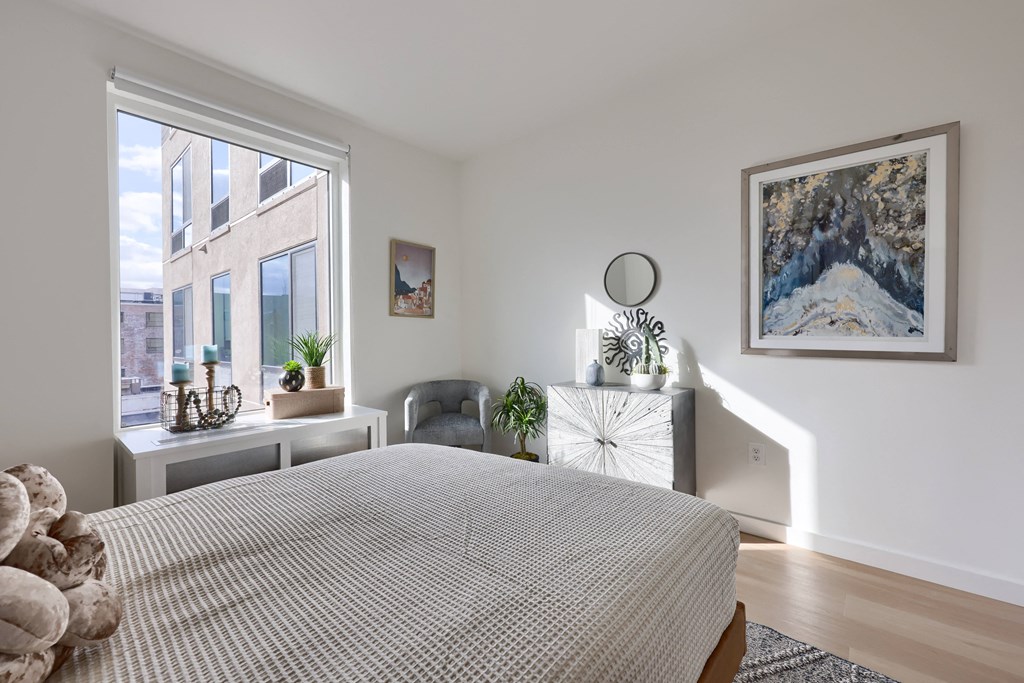 A bedroom with a large bed and a painting on the wall.