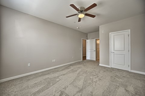 a living room with carpet and a ceiling fan