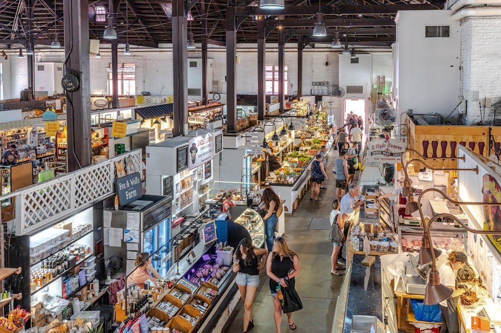 a large market hall with people walking around and buying food