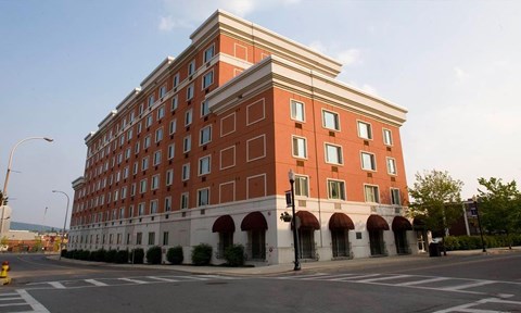 A large red brick building with arched windows and a white trim.