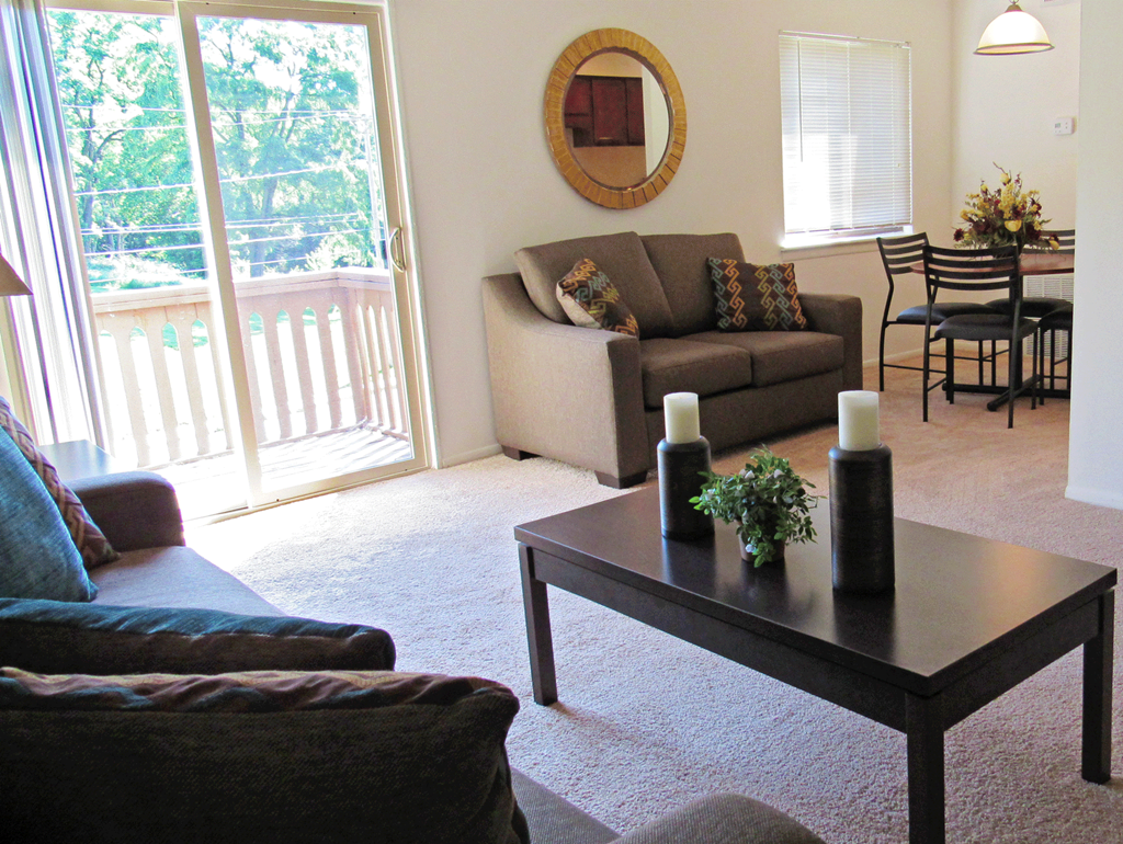 A living room with a couch, chairs, and a coffee table.
