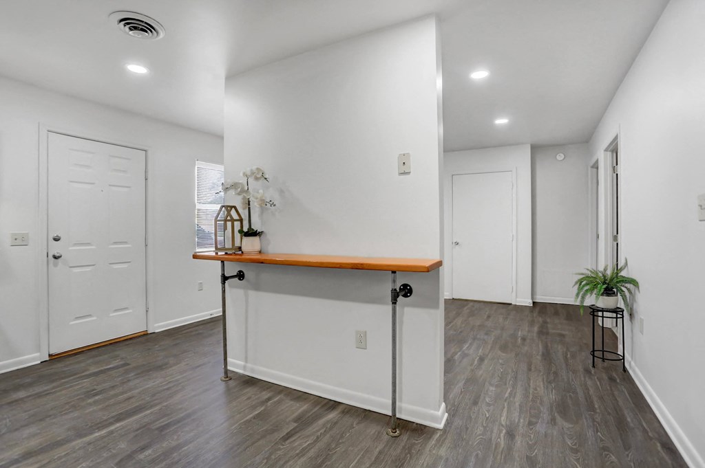 a living room with white walls and a counter in the middle