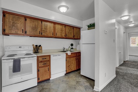 a kitchen with white appliances and wooden cabinets