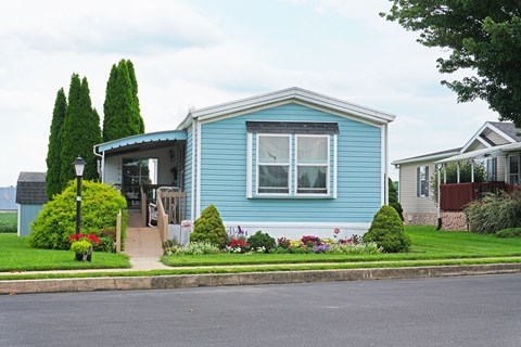 A blue house with a white roof and a small front yard.