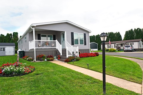 A house with a grey and white exterior and a small porch.