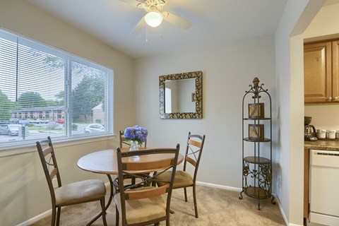 Mechanicsburg Apartments | Delbrook Manor Apartments | a dining room with a large window and a ceiling fan