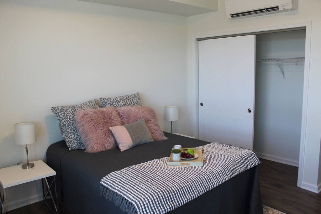 a bedroom with a bed and a table with a tray of food on it