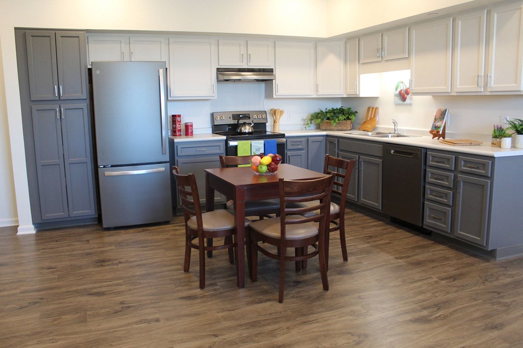 a kitchen with gray cabinets and a wooden table in the middle