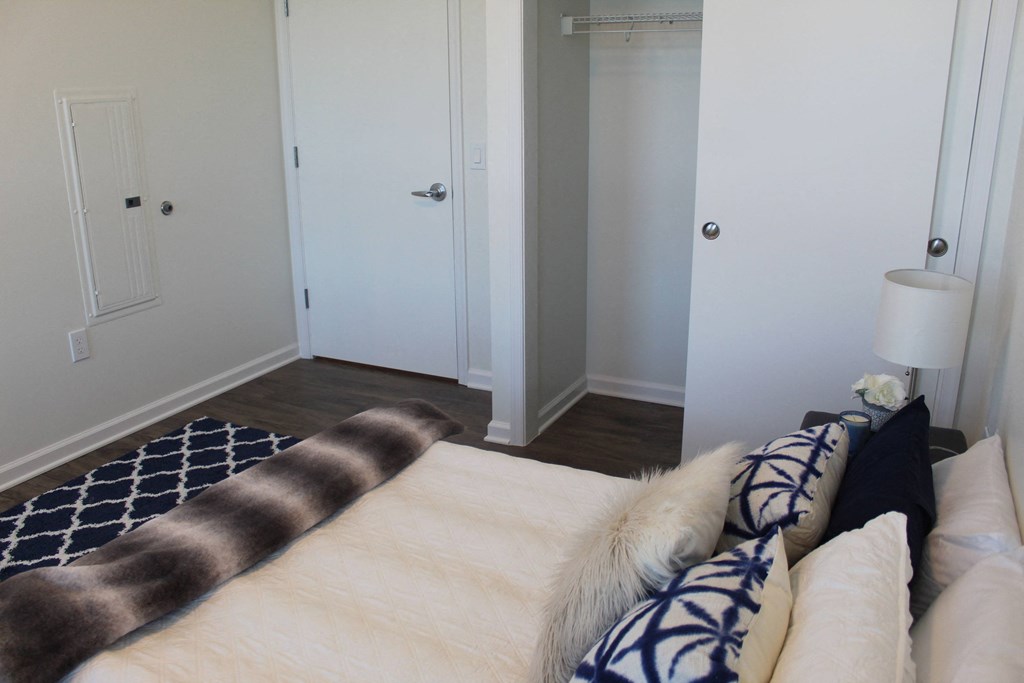 a bedroom with white walls and a bed with brown and blue pillows