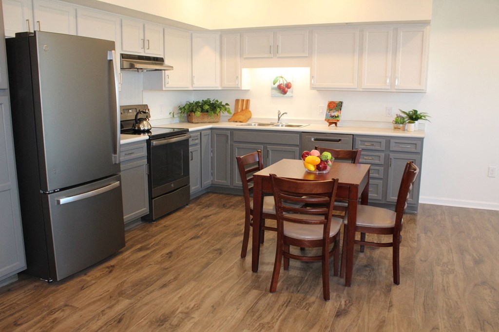 a kitchen with a table and chairs and a refrigerator