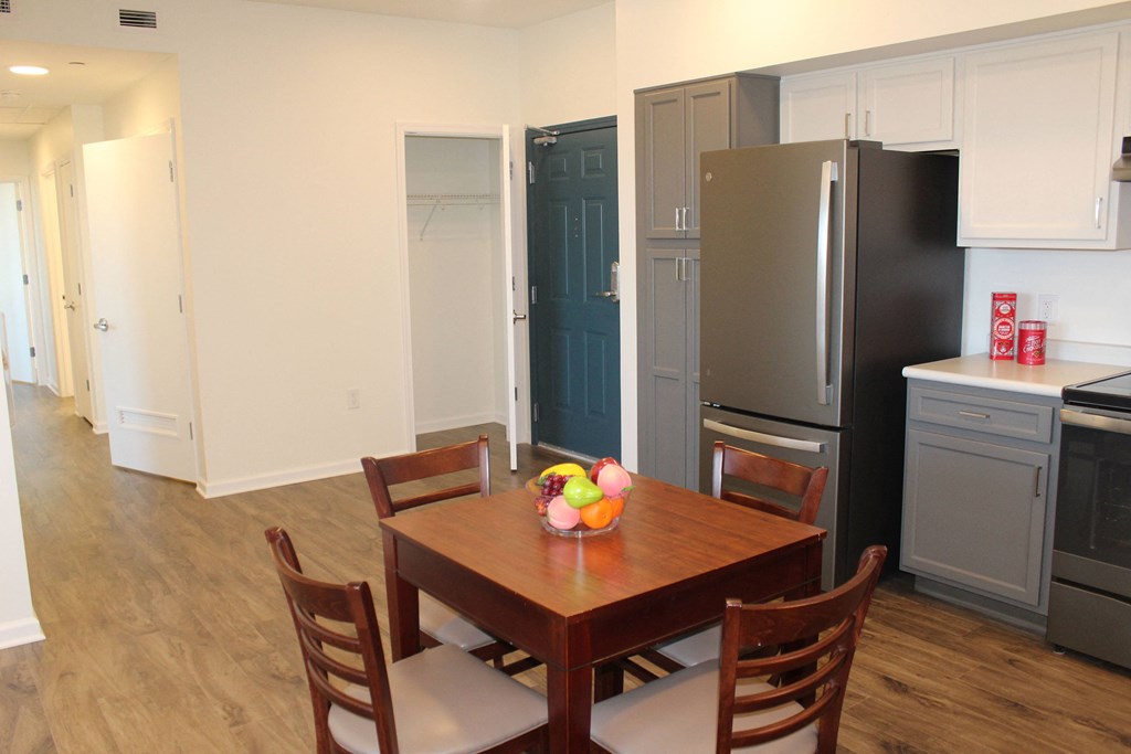 a kitchen and dining room with stainless steel appliances and a wooden table