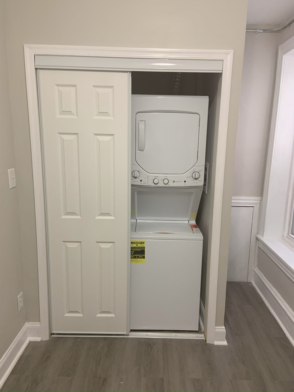 A white door with a small fridge in it.