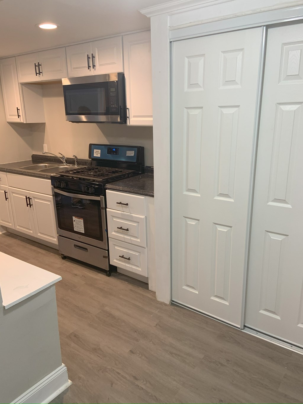 A kitchen with white cabinets and a black stove top oven.