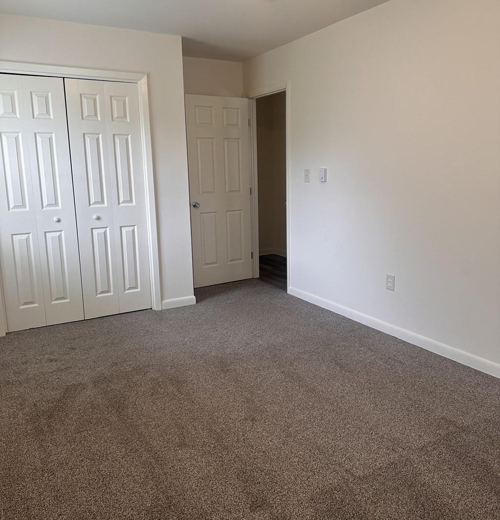 A room with a carpeted floor and white walls.