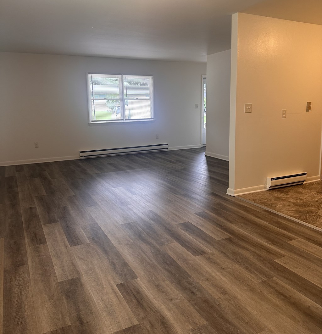 A room with wooden flooring and a window.