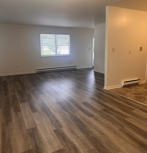 A room with wooden flooring and a window.